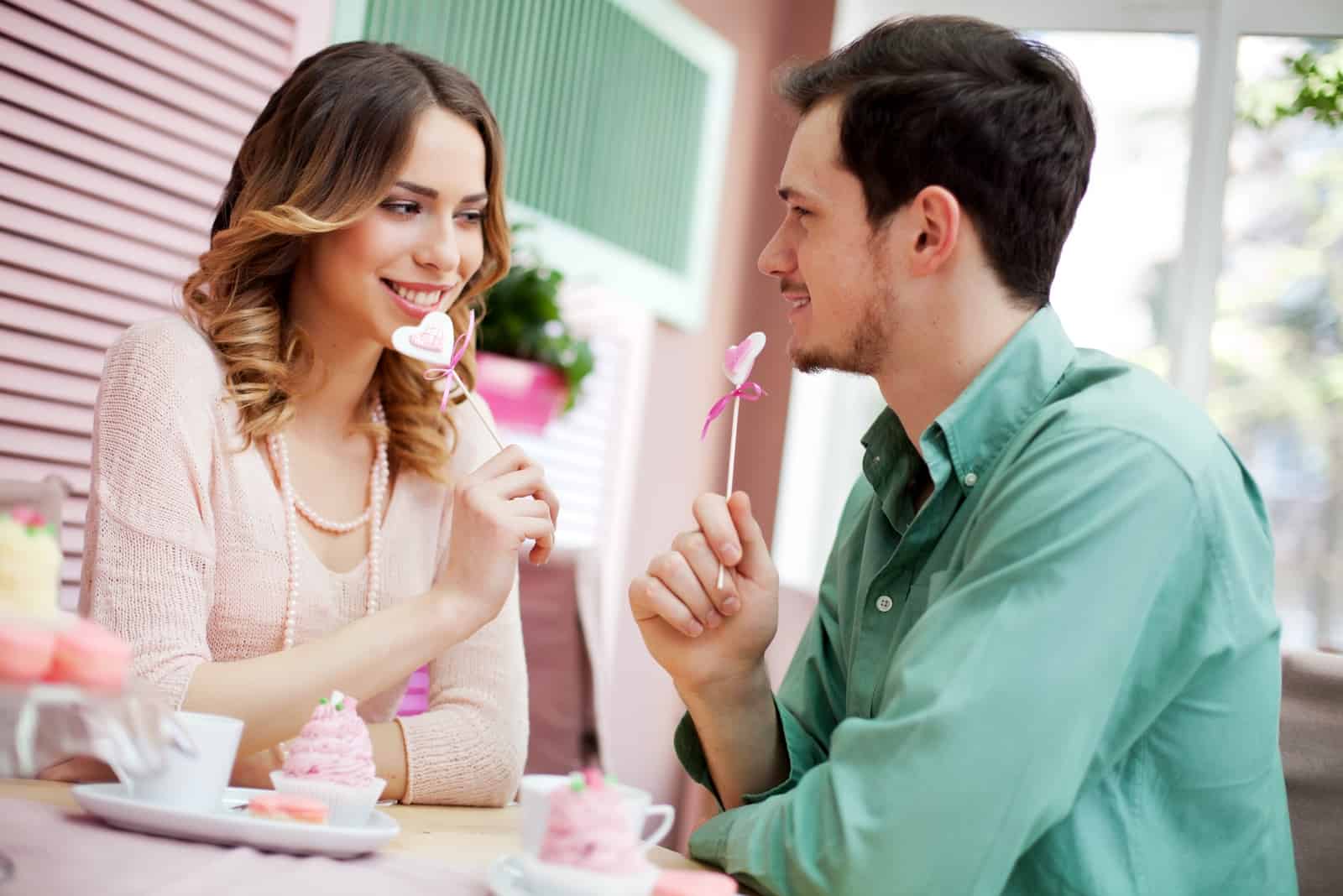 pareja flirteando sentada en una cafetería