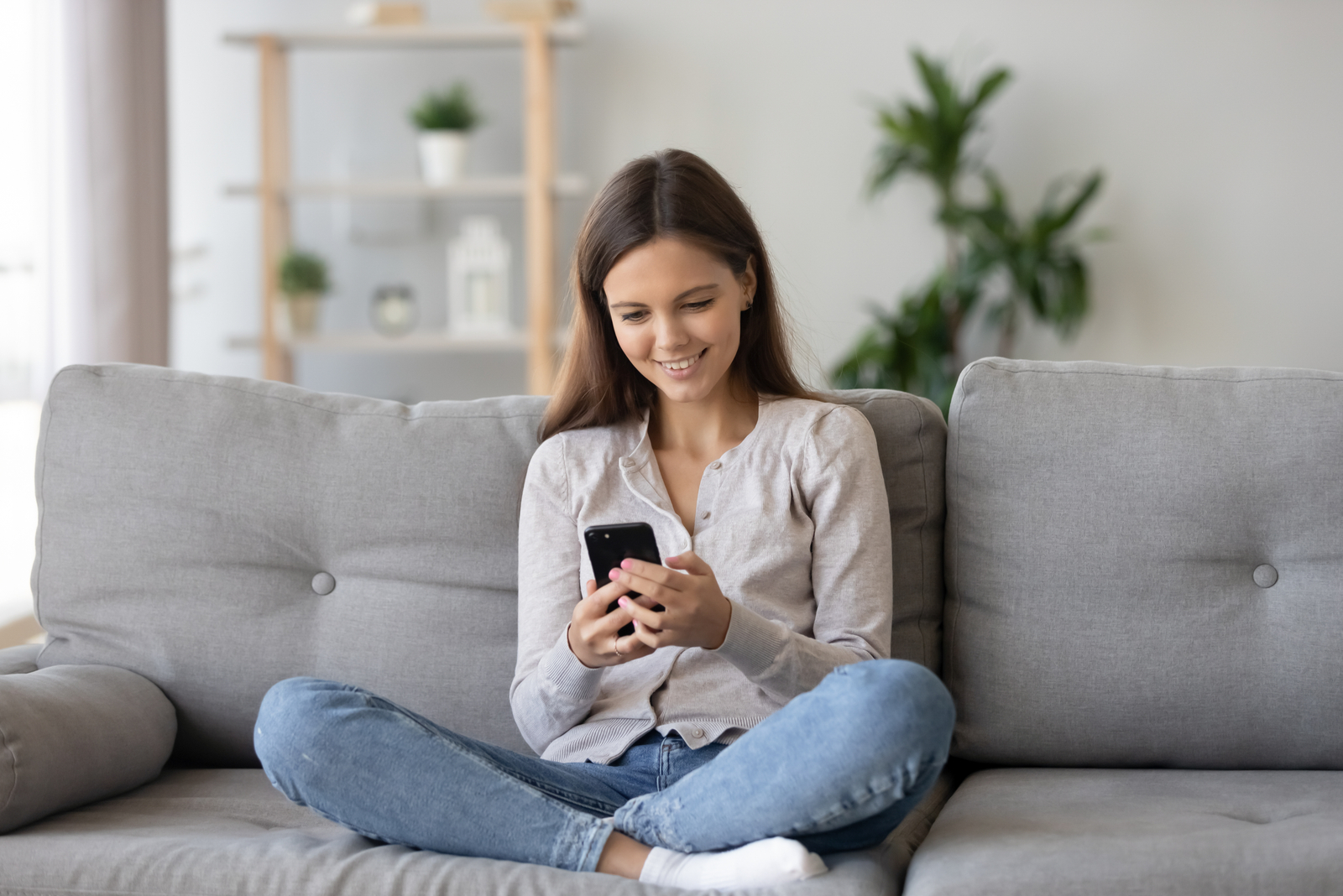 mujer joven feliz enviando mensajes de texto en el teléfono