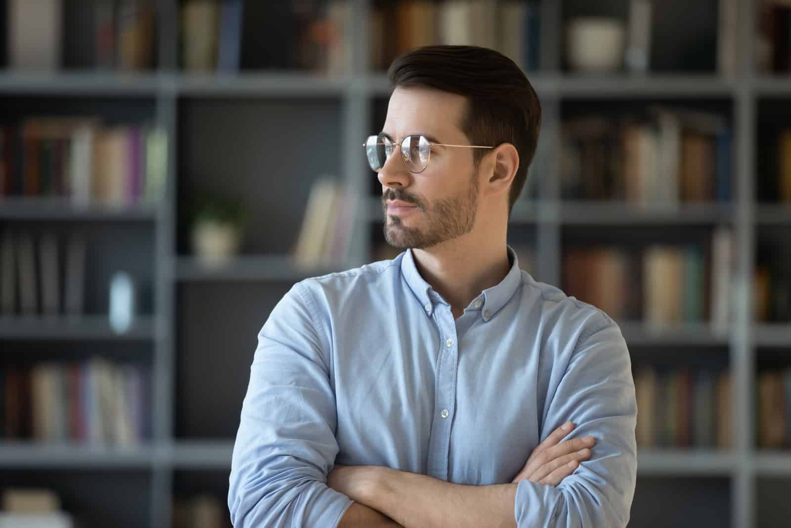 serious man with glasses standing and looking at distance