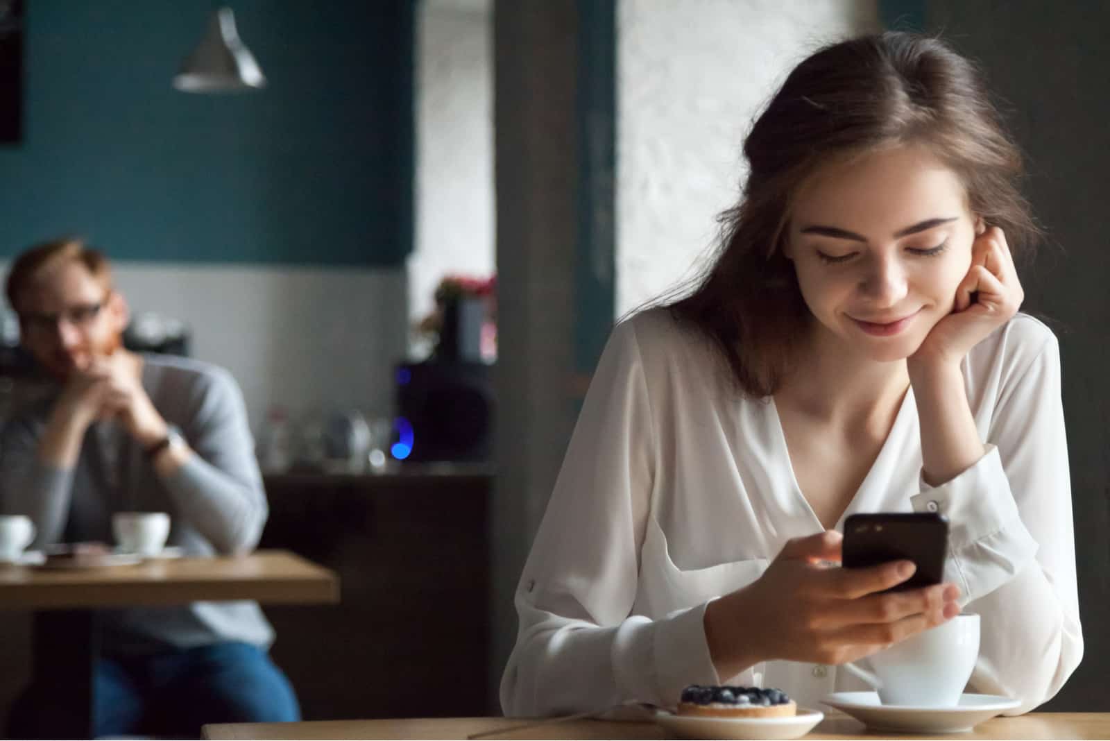 jovem rapariga ao telemóvel num café