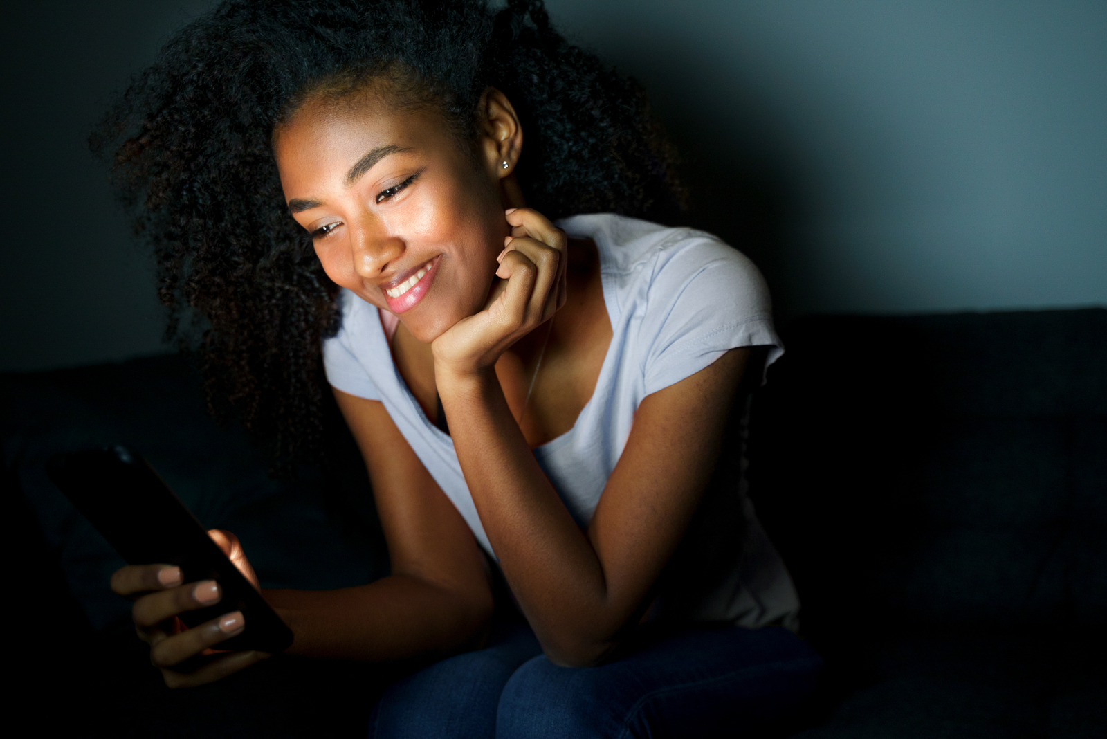 young woman reading messages in dark