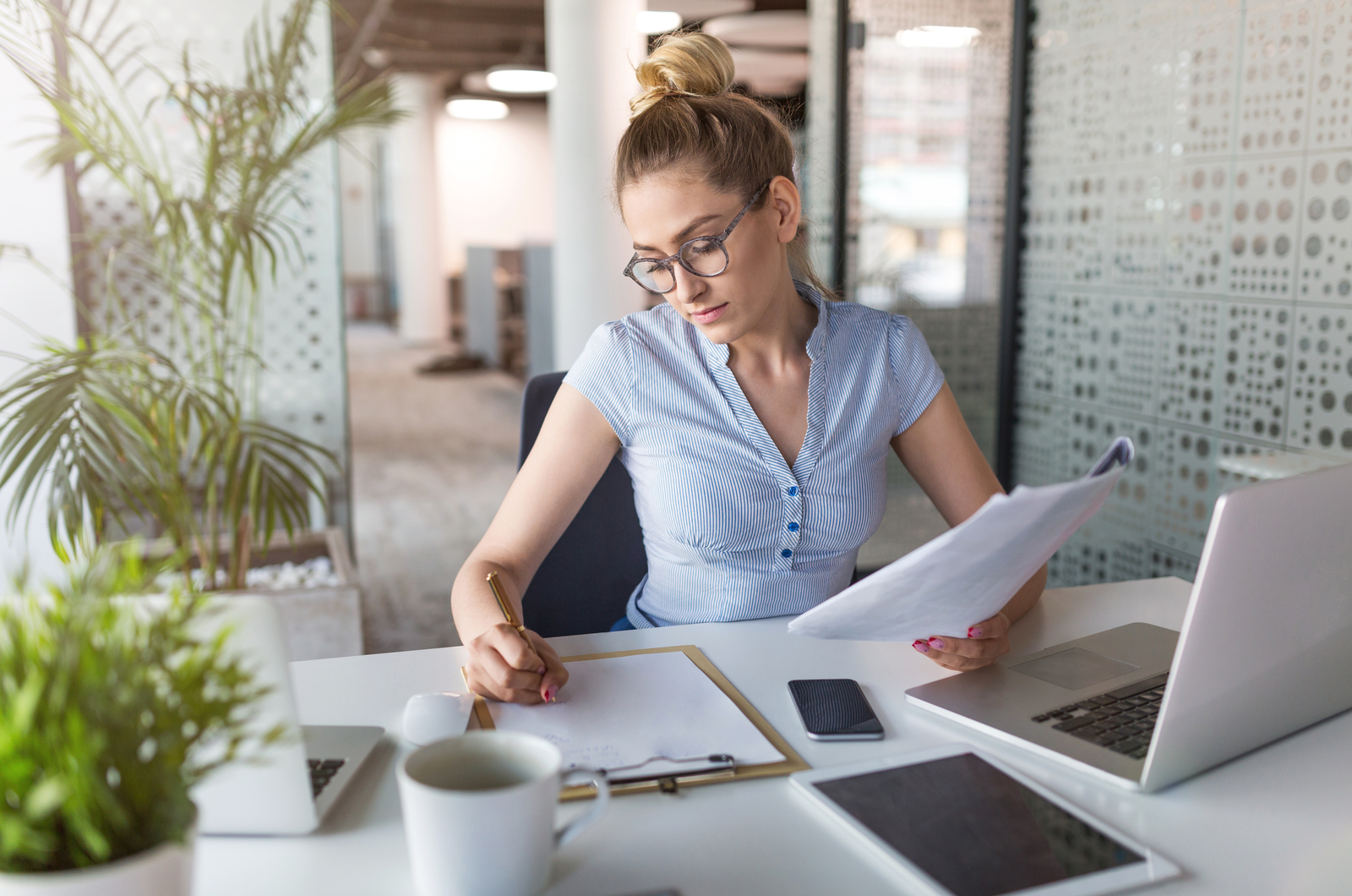 young woman writing something while working