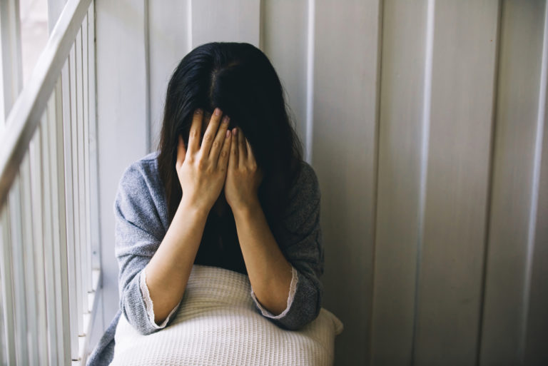 woman crying and covering her face