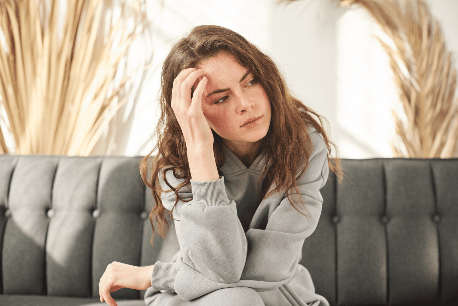pensive woman sitting on the couch