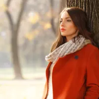 an imaginary woman leaning against a tree