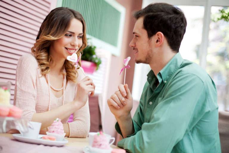 couple sitting in cafe looking at eachother