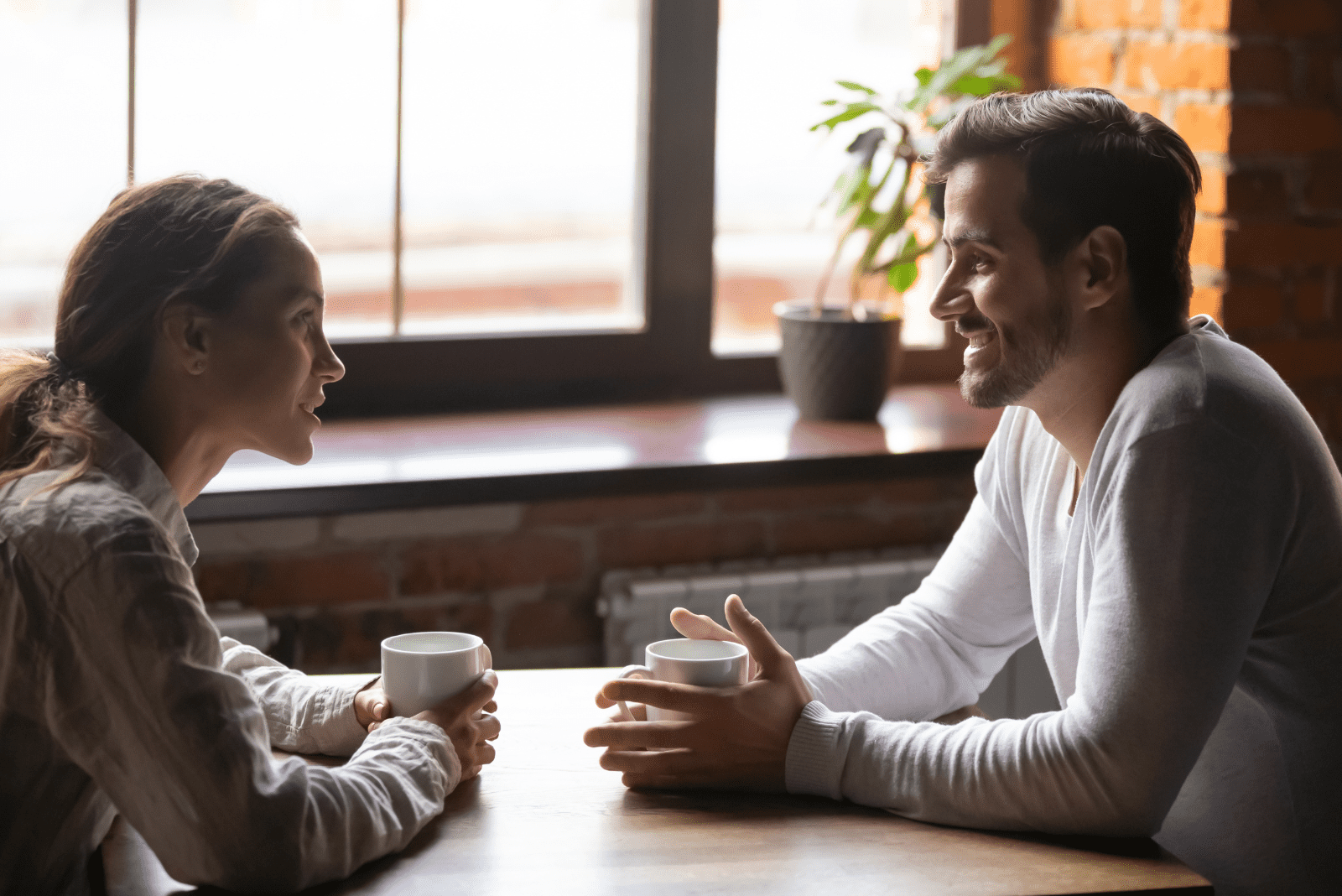 um homem e uma mulher estão sentados à mesa a conversar