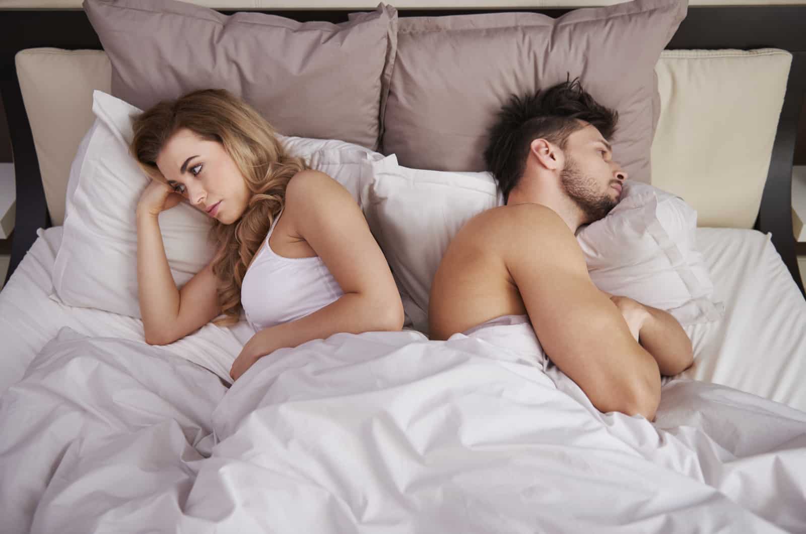 angry couple lying in bed