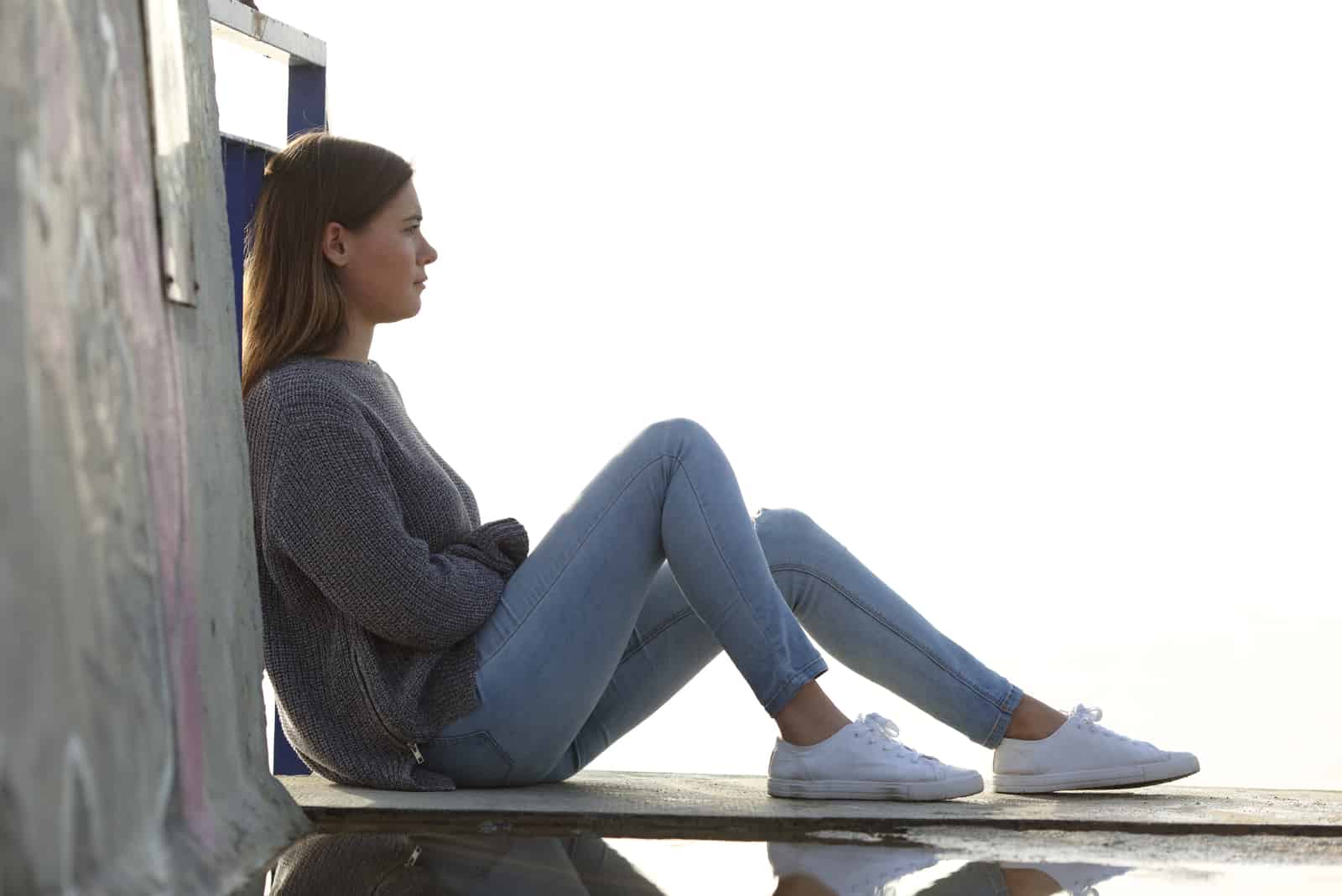 pensive woman sits on the pier
