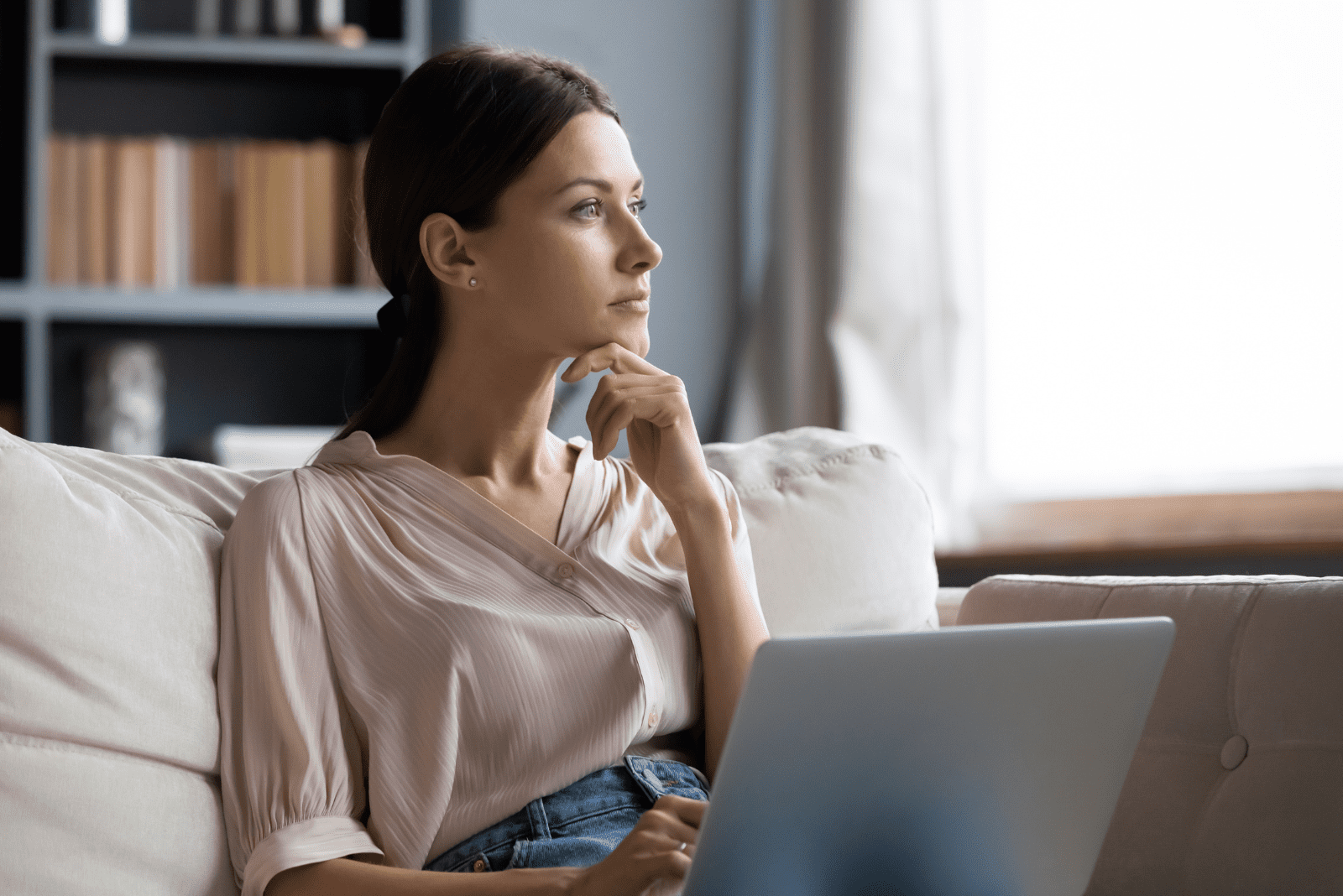 pensive woman sitting on the couch