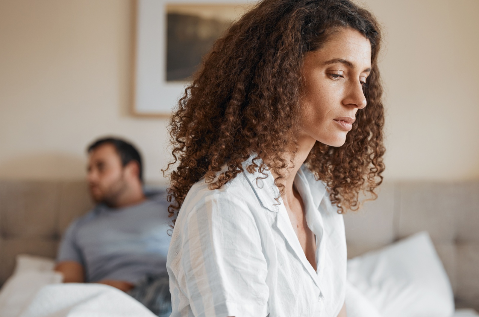 mujer triste sentada al borde de la cama