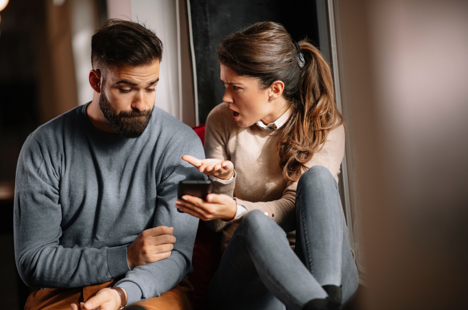 mujer mostrando un teléfono a un hombre