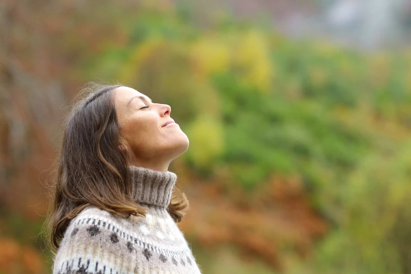 woman taking a deep breath in nature