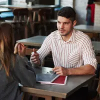 a man and a woman are sitting at the table and talking