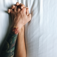 couple holding hands in bed