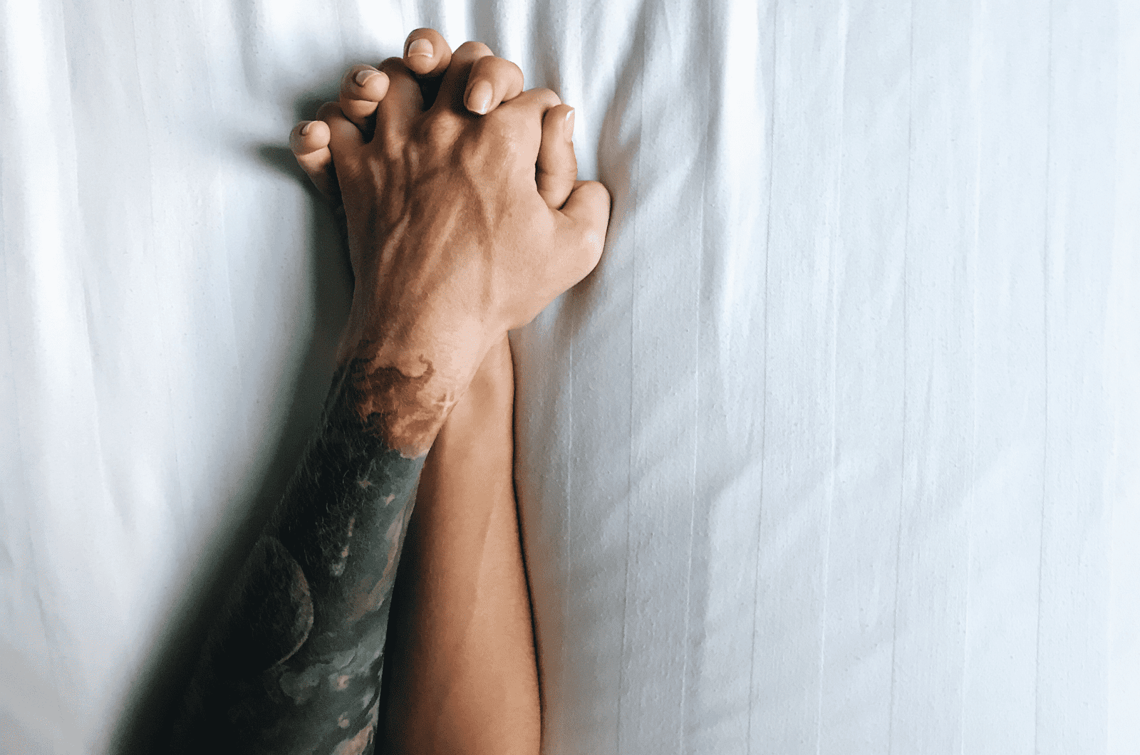 couple holding hands in bed