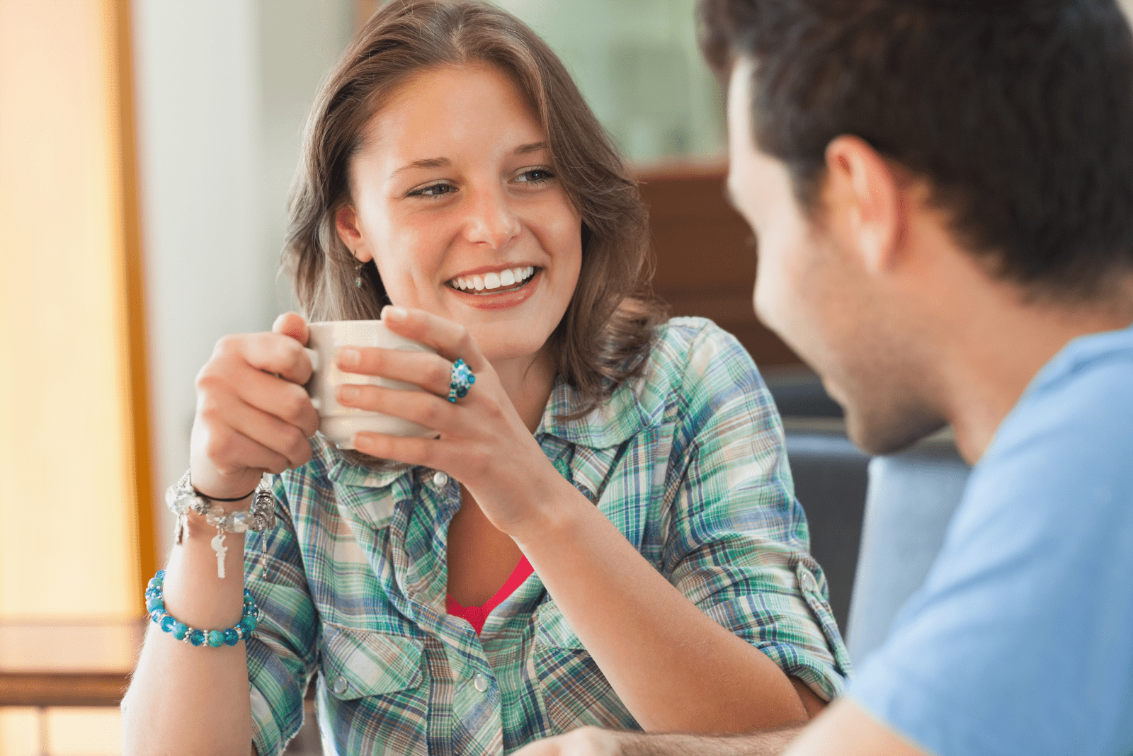 Una donna sorridente tiene in mano una tazza e stanno parlando
