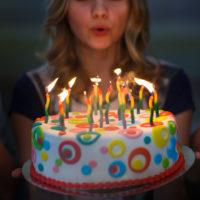girl blowing out candles