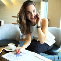 una donna sorridente siede al telefono e lavora