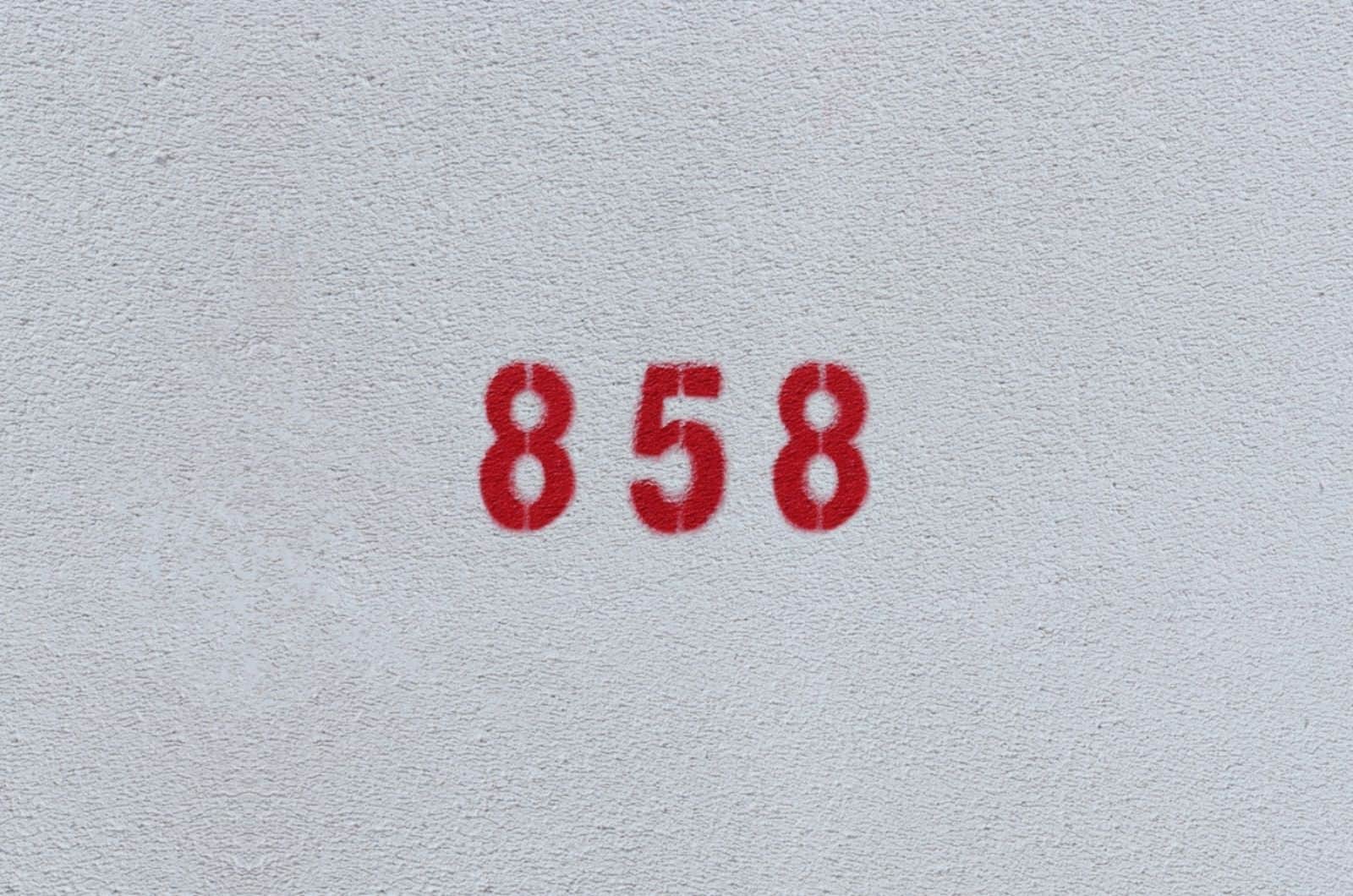 ROJO Número 858 en la pared blanca