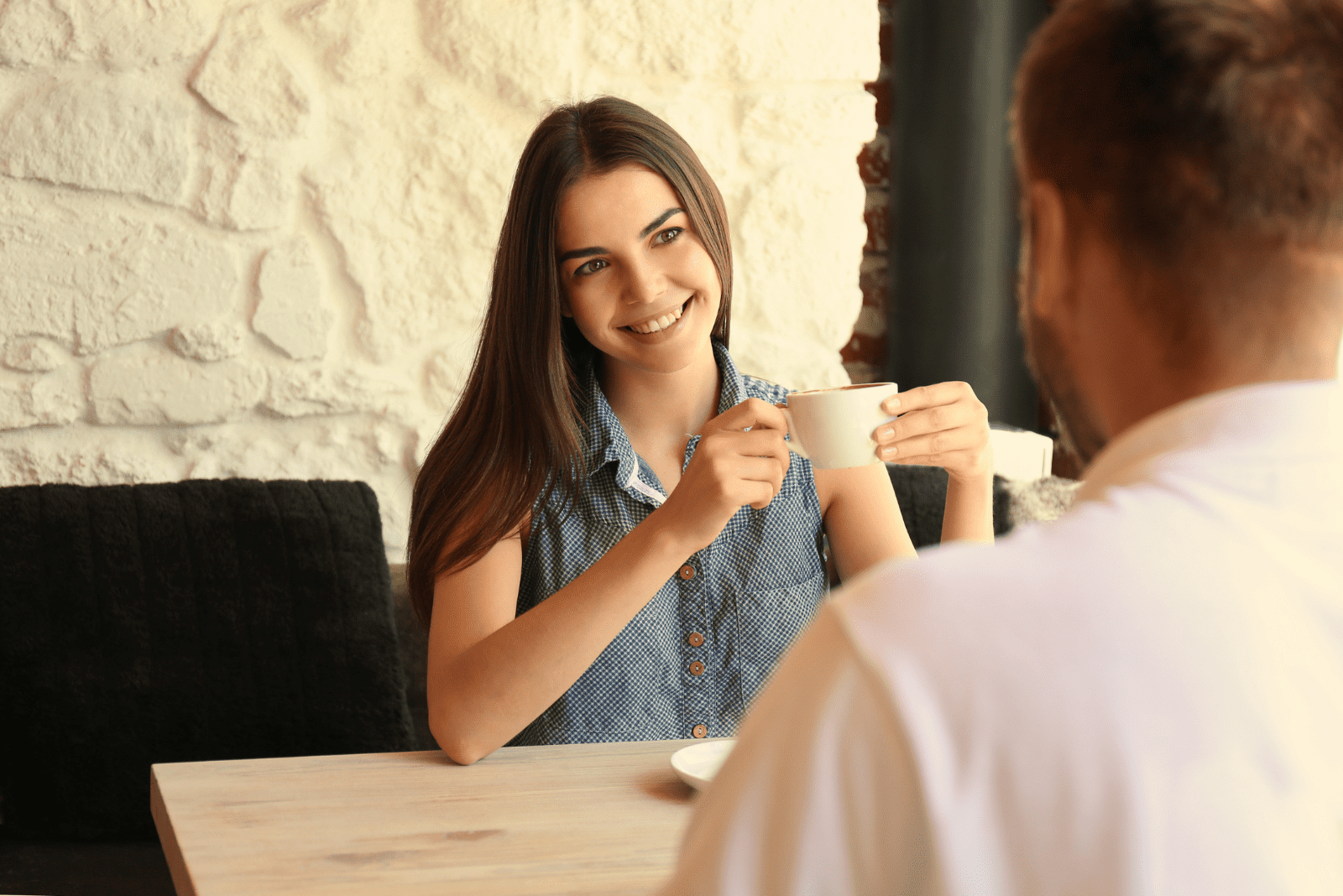 a beautiful woman drinks coffee with a man