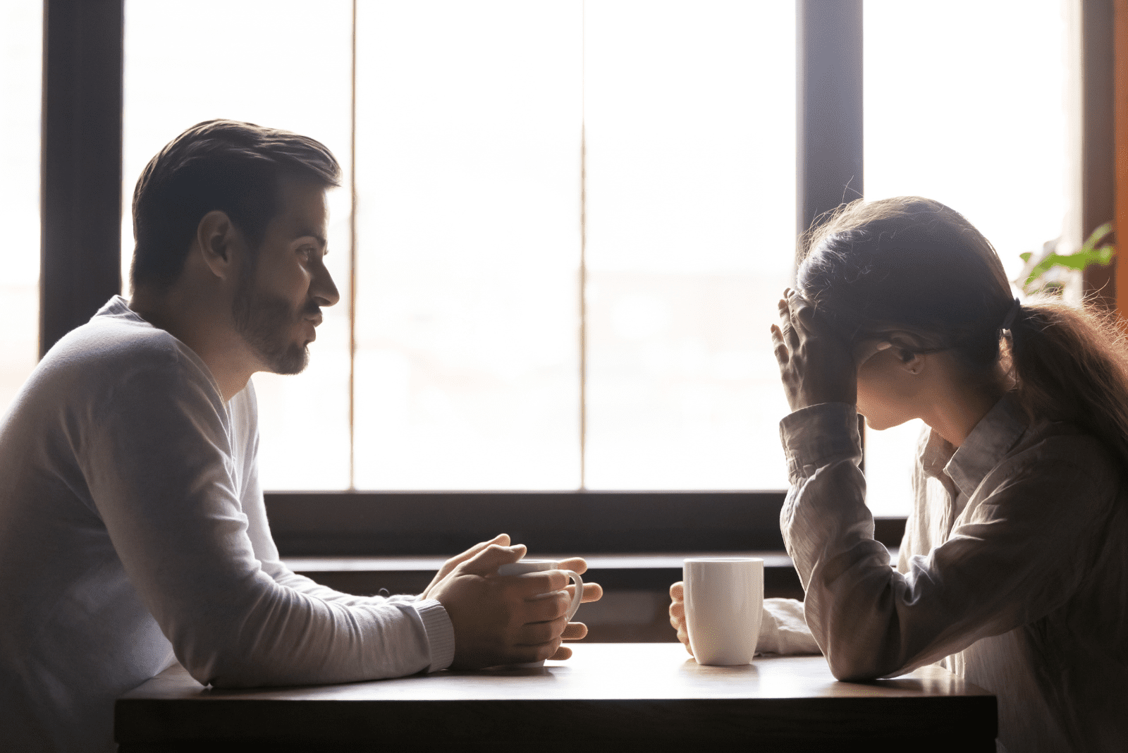 un hombre y una mujer están sentados en un café y hablan