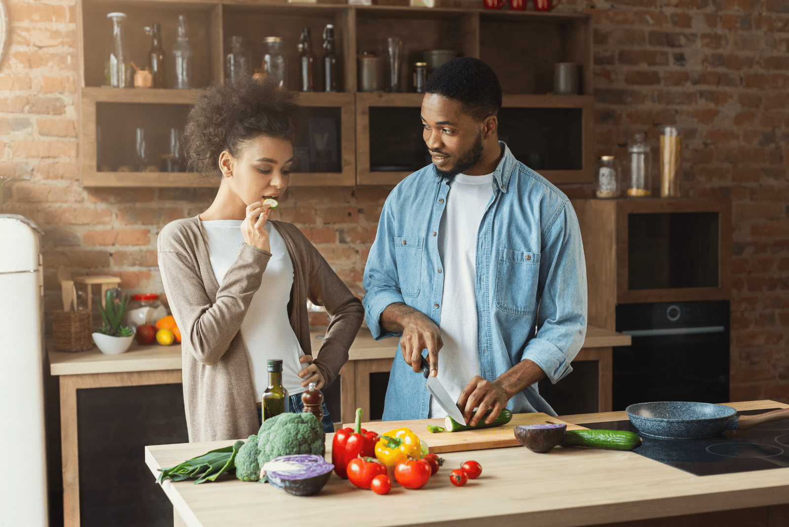 a man and a woman are standing in the kitchen