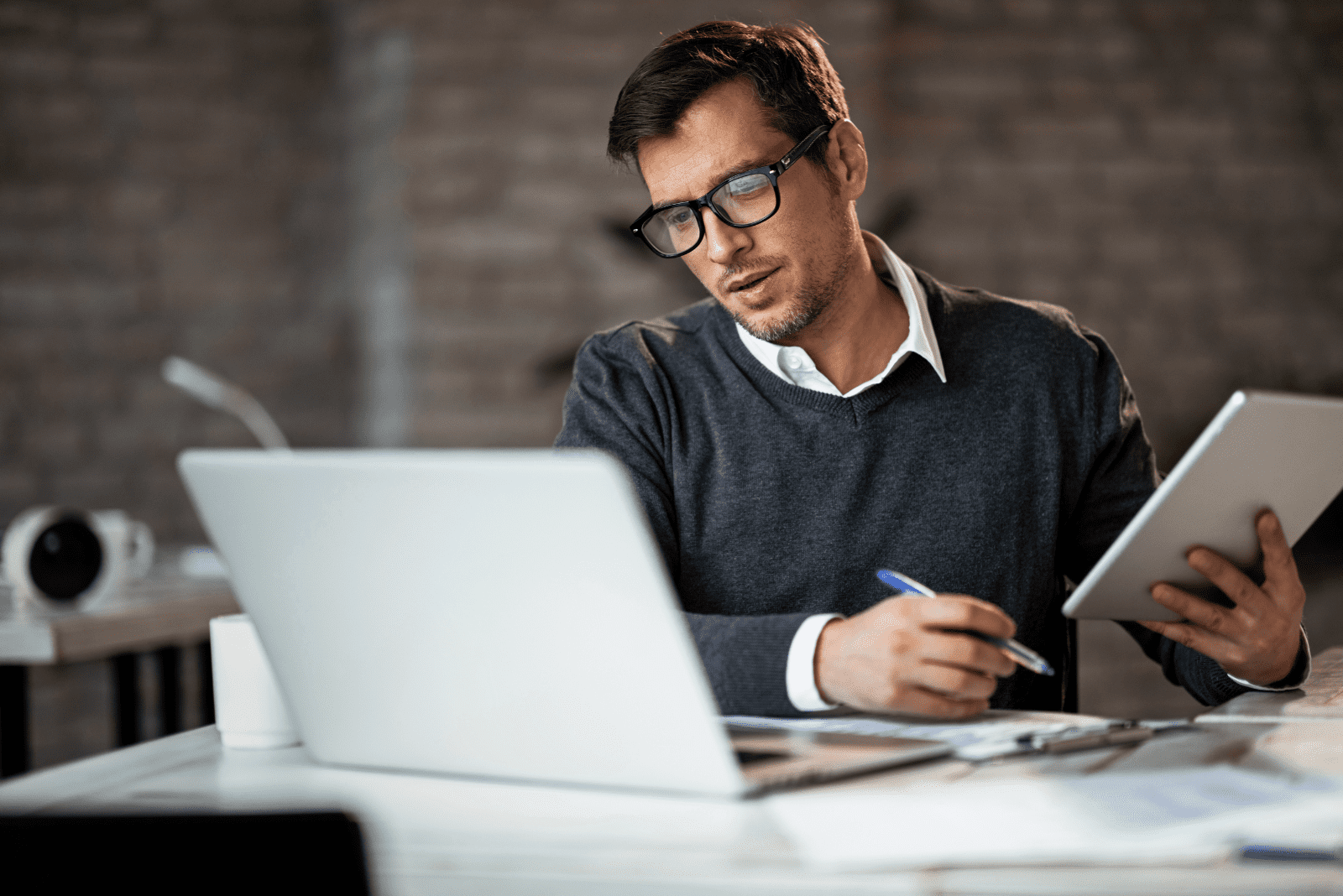 a man with glasses works in the office