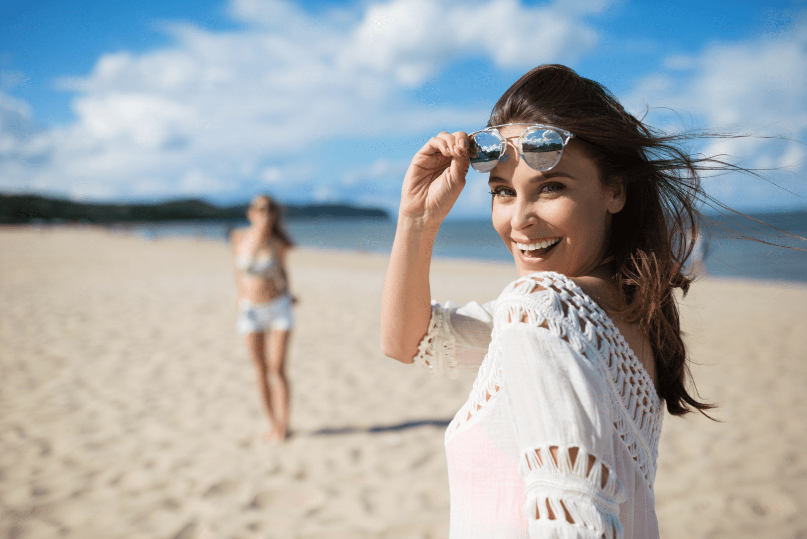 bella donna sorridente in piedi sulla spiaggia