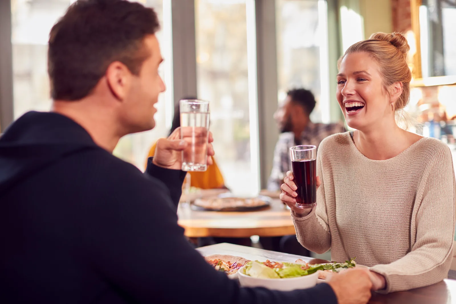 smilende par på date nyter pizza i restaurant sammen