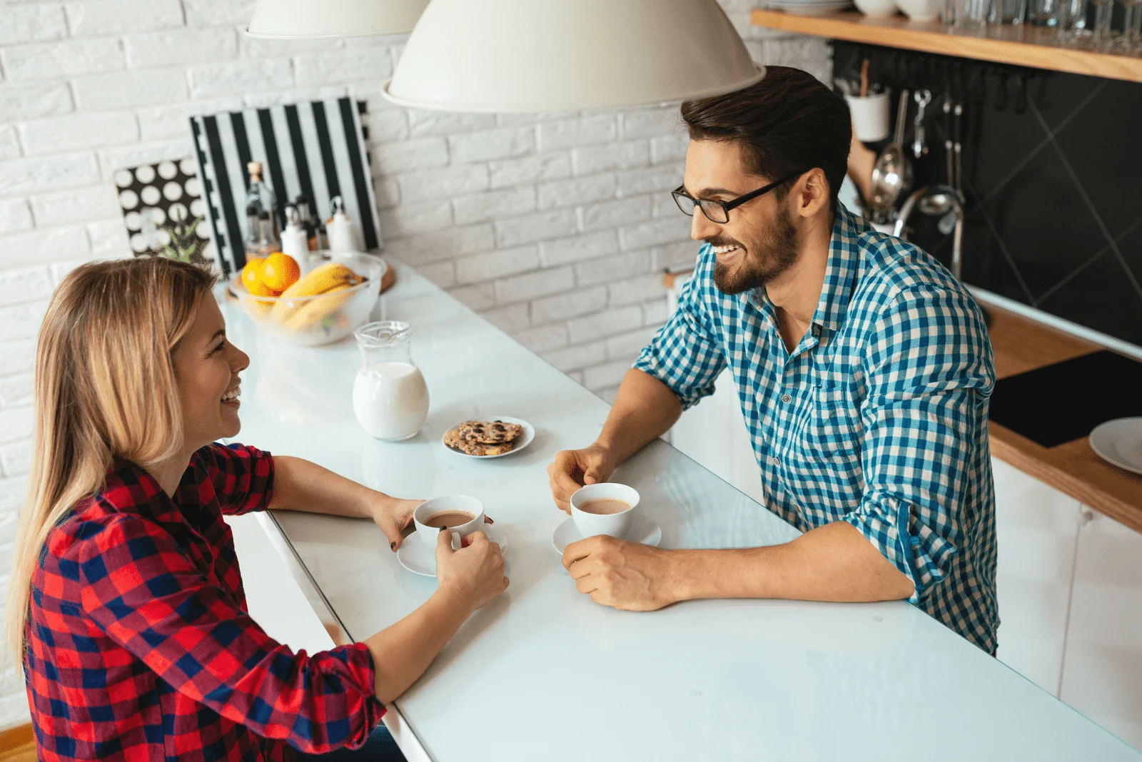 smiling man and woman sitting in the kitchen and talking