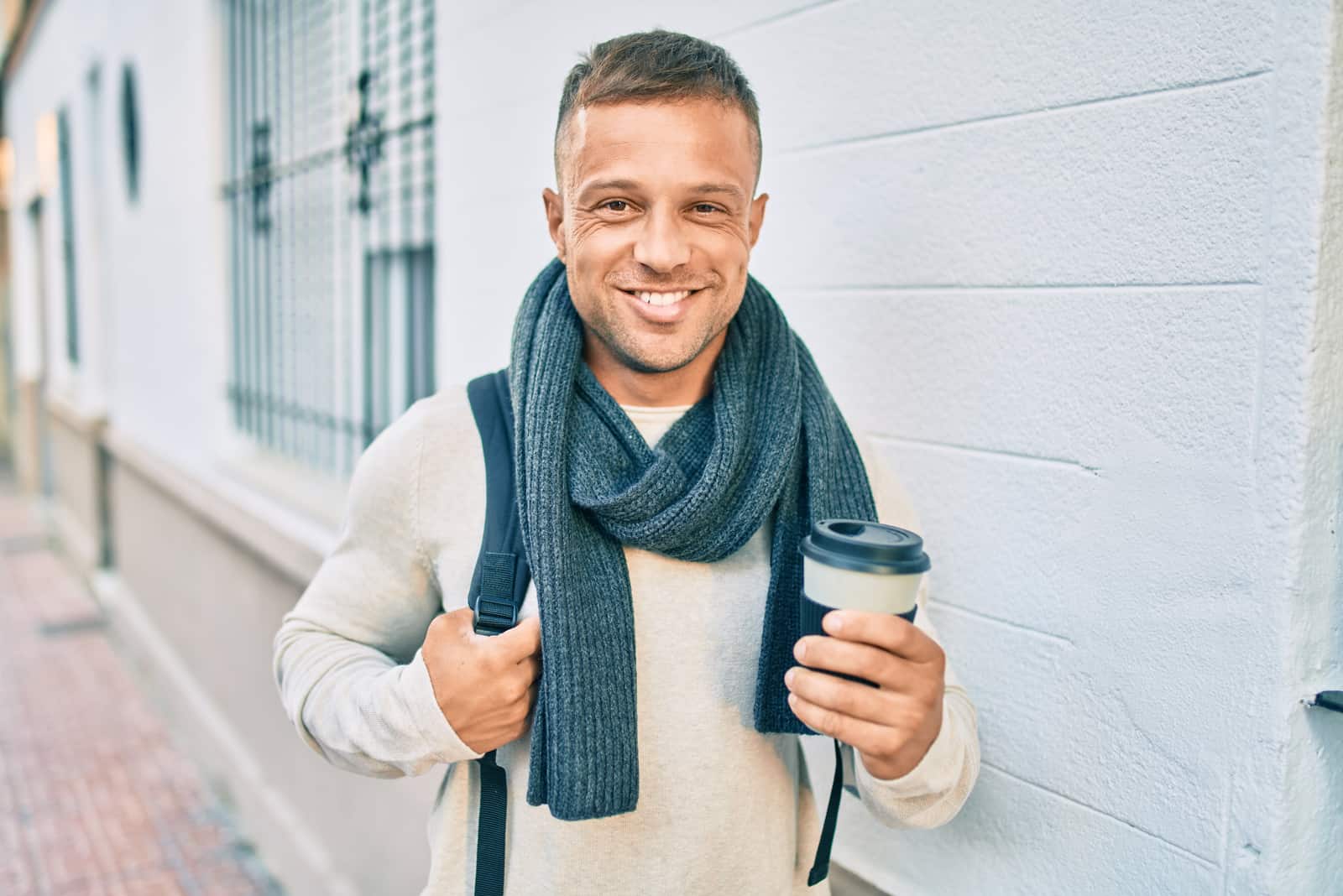 hombre sonriente con una taza de café en la mano