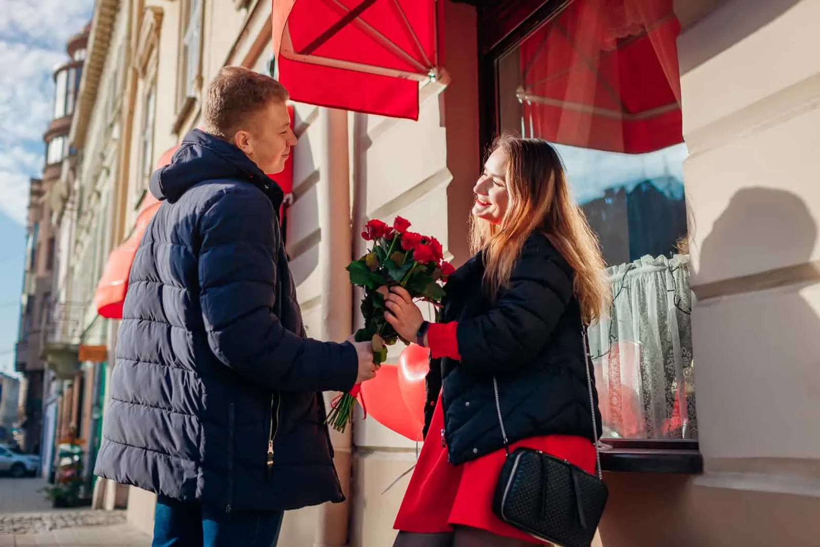 woman accepts flowers from man