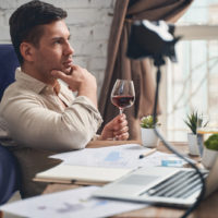 man sitting on floor drinking wine