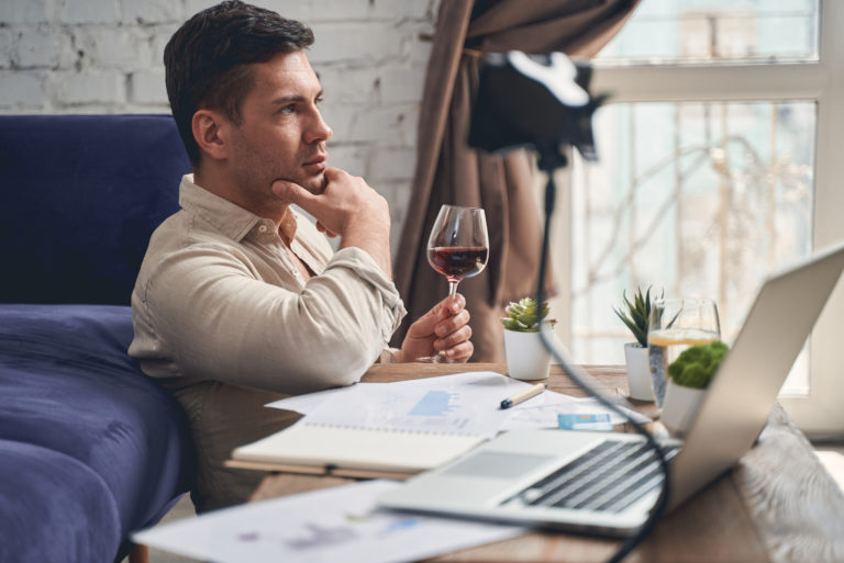 man sitting on floor drinking wine
