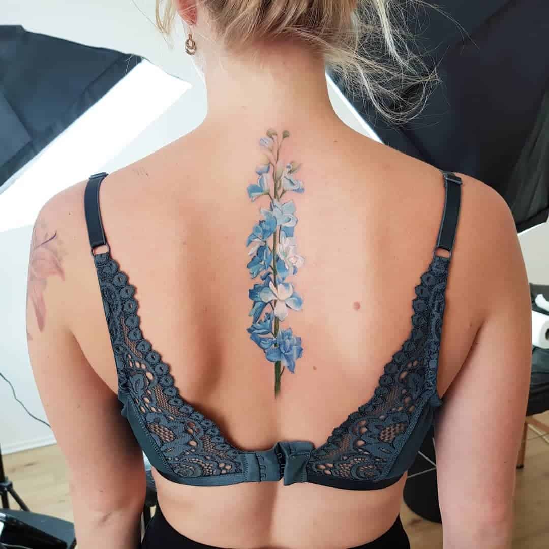 Blue flower spine tattoo