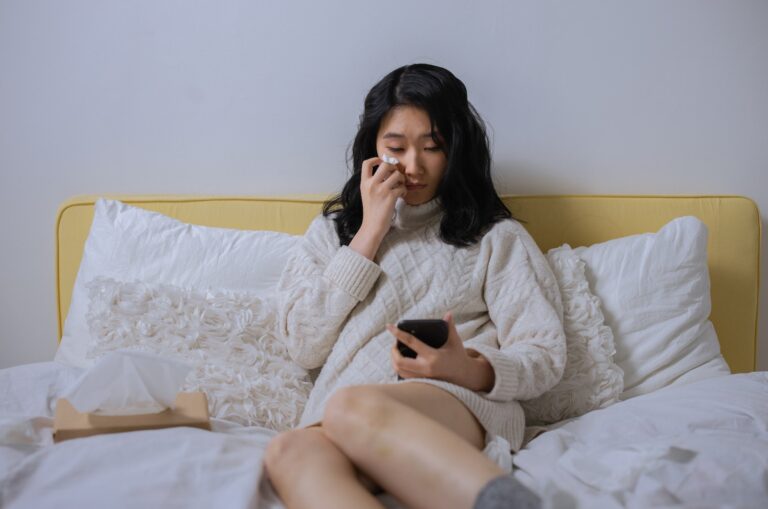 girl sitting on a sofa reading about how to apologize to your boyfriend over text