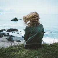 woman sitting on cliff