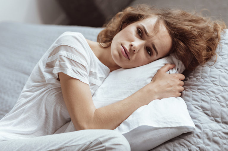 sad woman hugging pillow