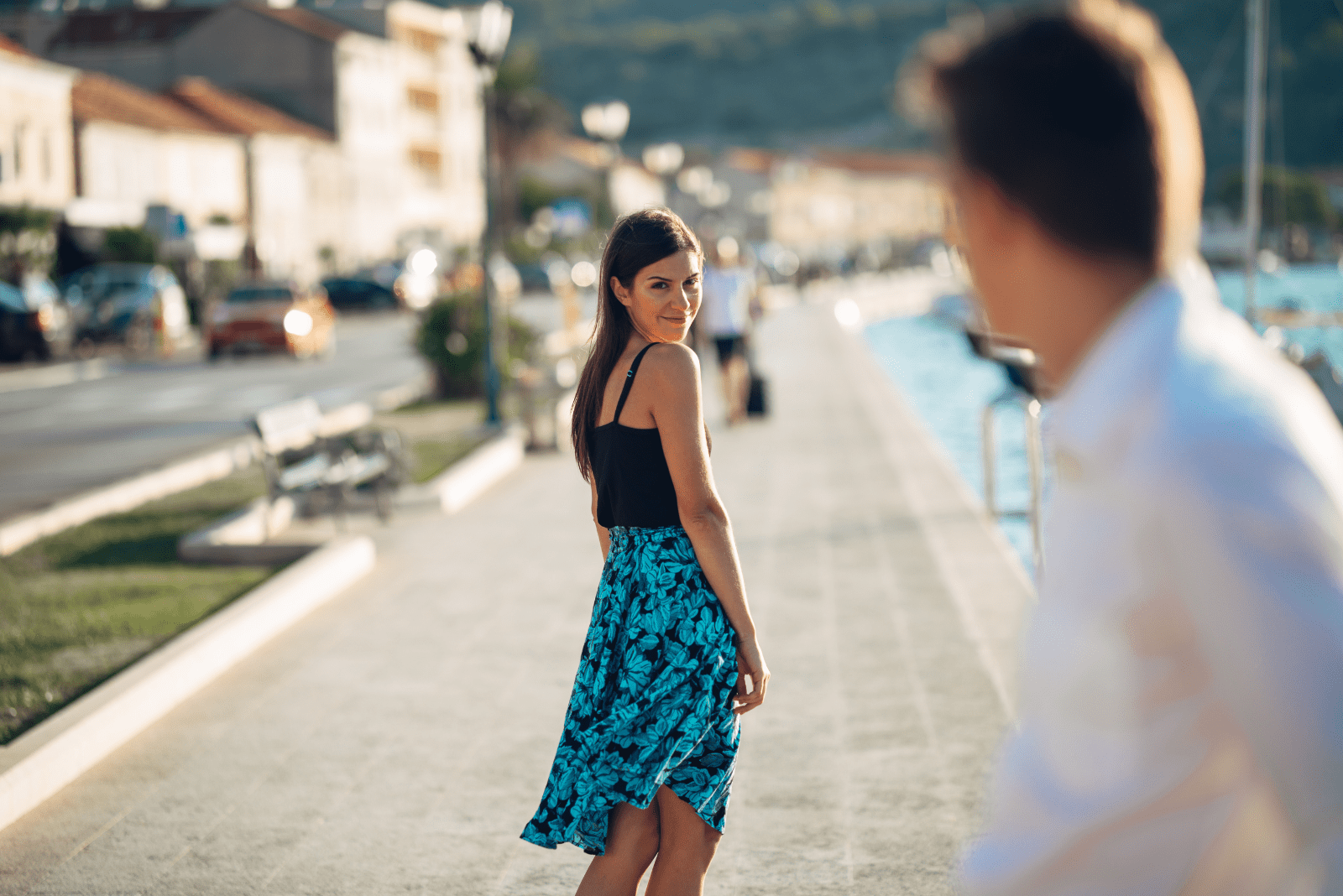 a man looks at a woman walking down the street