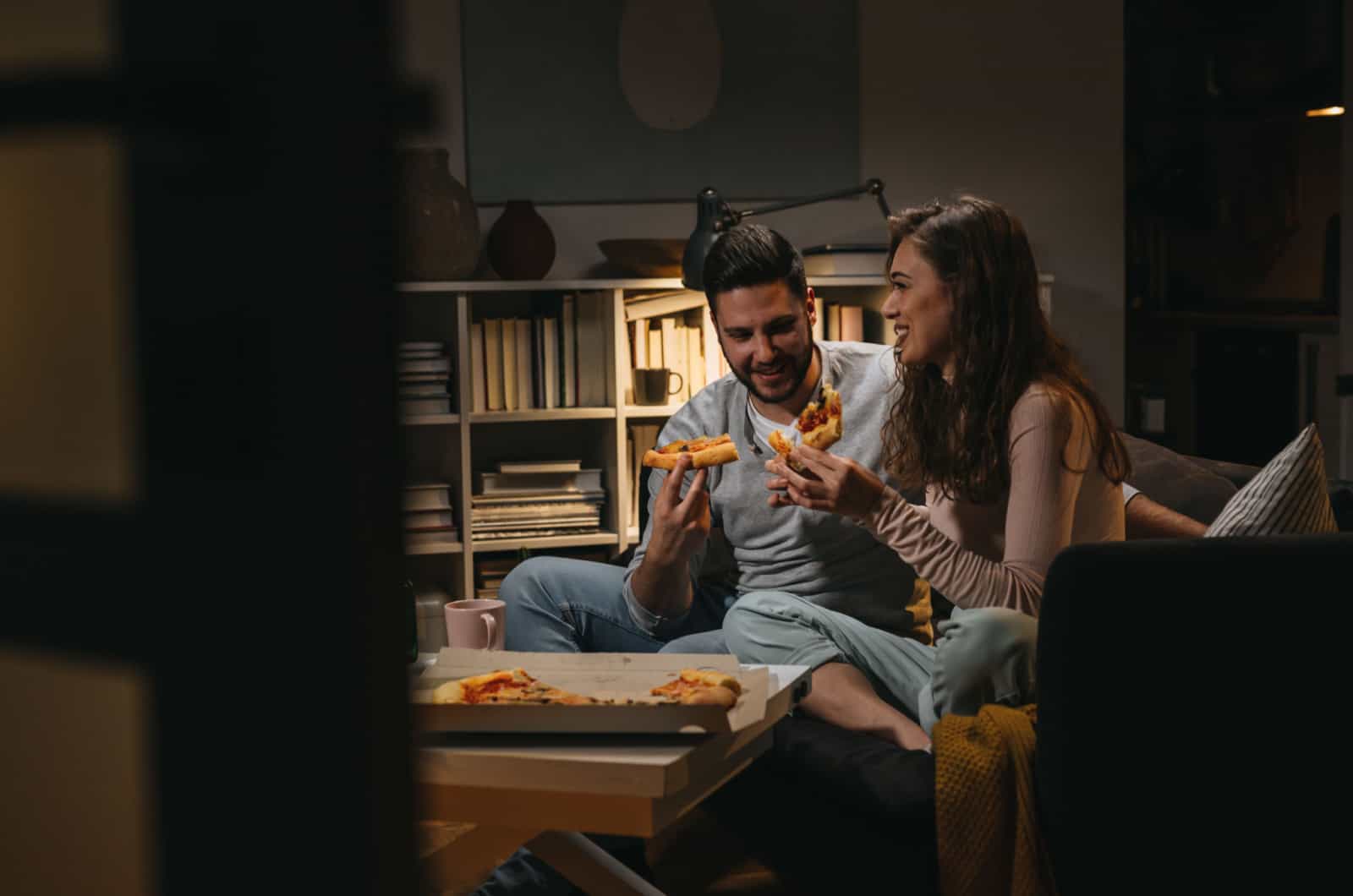 pareja comiendo pizza en casa