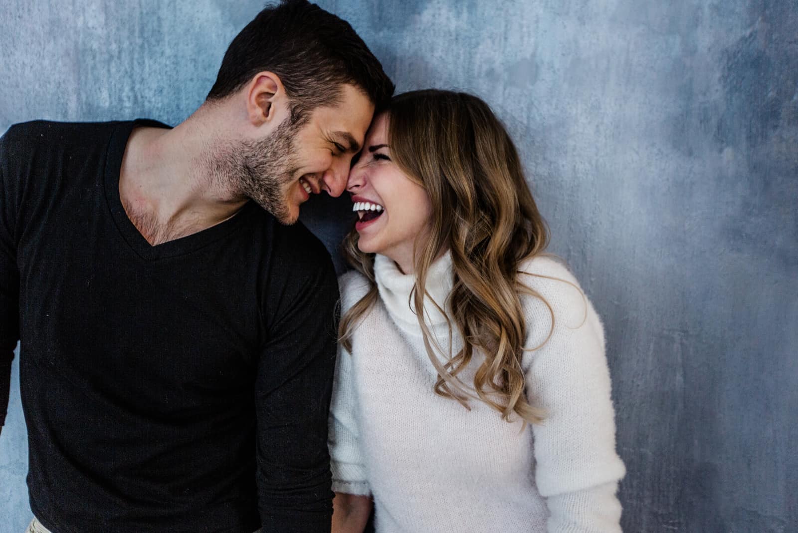 laughing couple with blue background