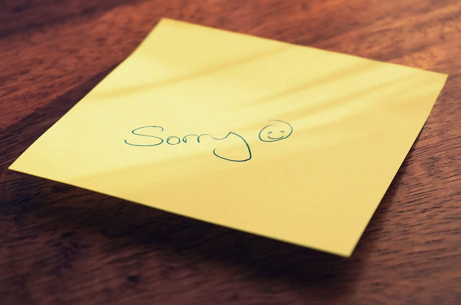 sorry written on a yellow piece of paper