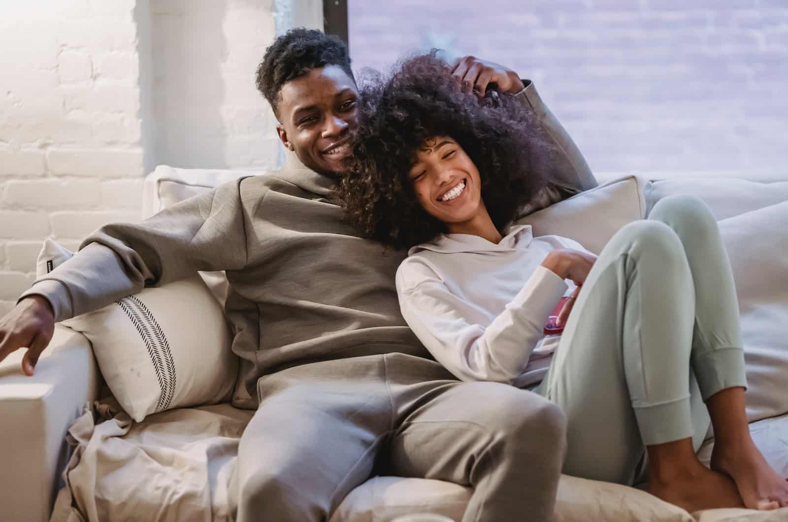 woman and man snuggling on a couch and celebrating their bond