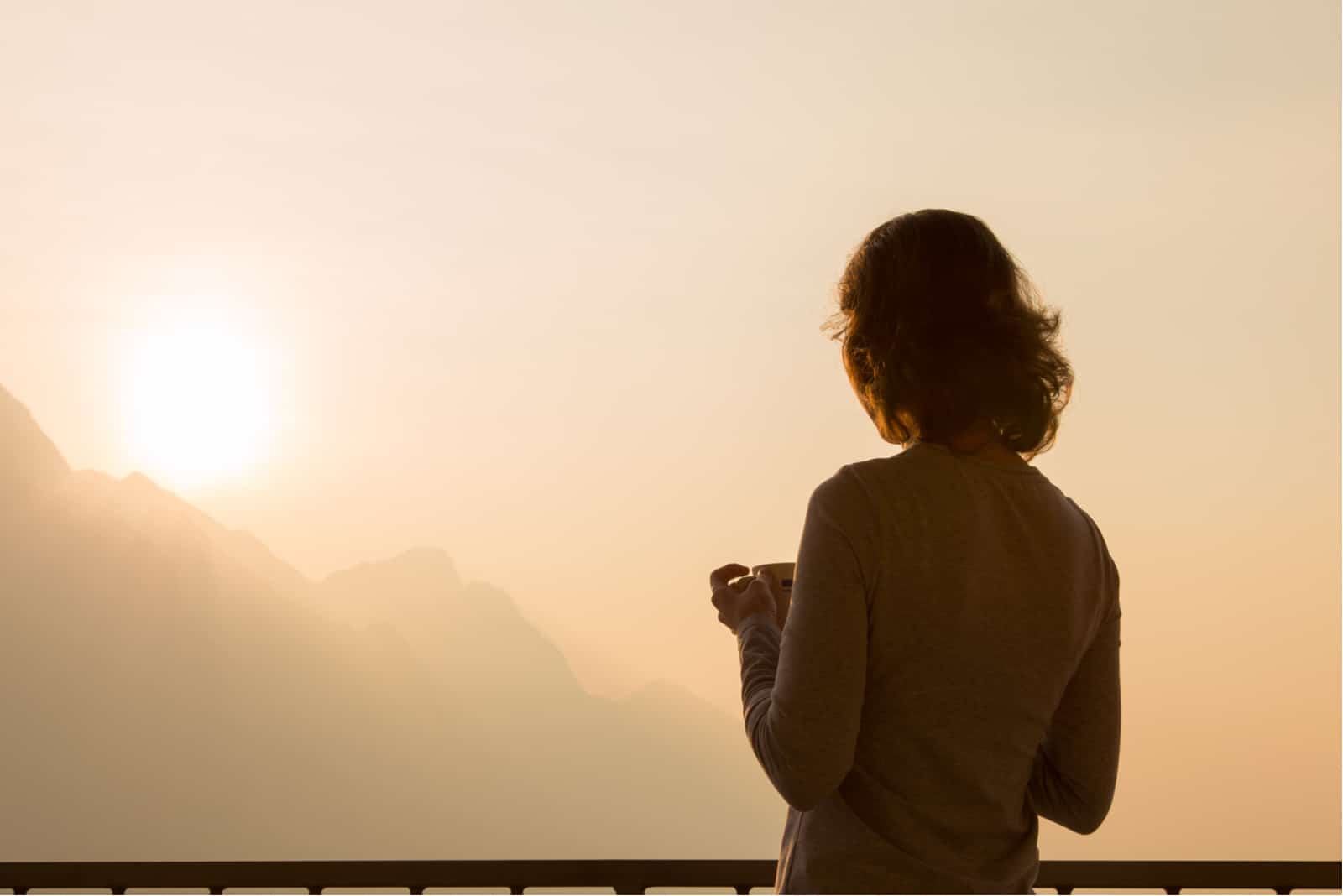 mujer mirando sola la puesta de sol