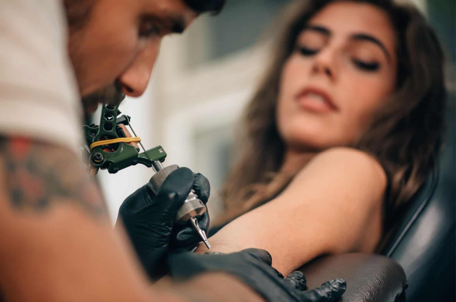 donna che si fa tatuare il braccio