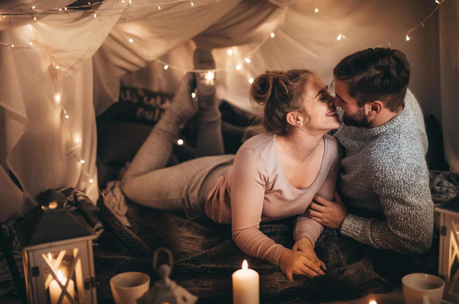 couple kissing in a romantic atmosphere with candles and lights