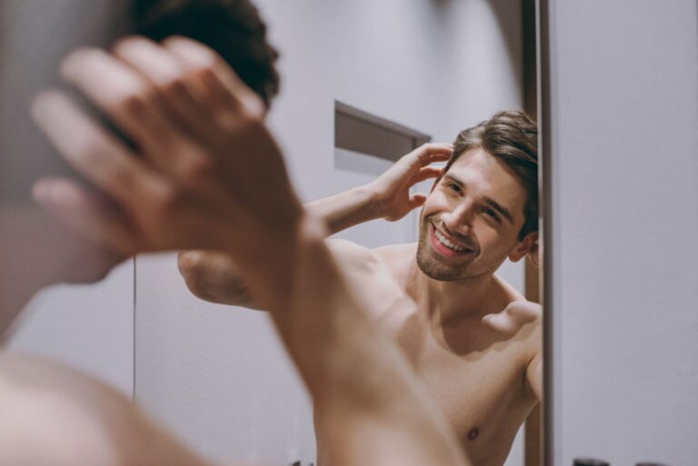 smiling man looks at mirror