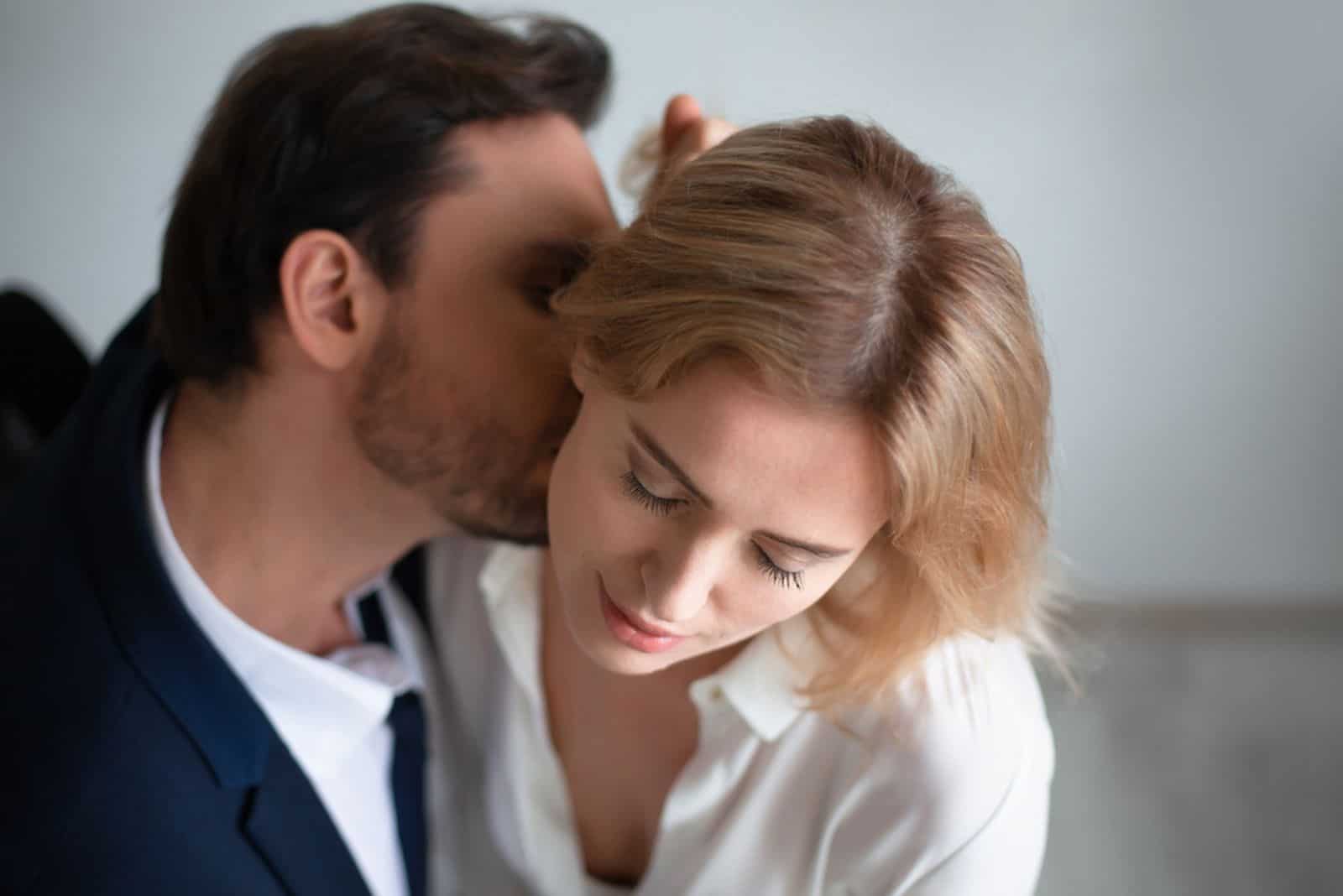 Business man kissing neck of young blonde woman