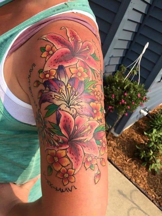 Colorido tatuaje floral en la parte superior del brazo